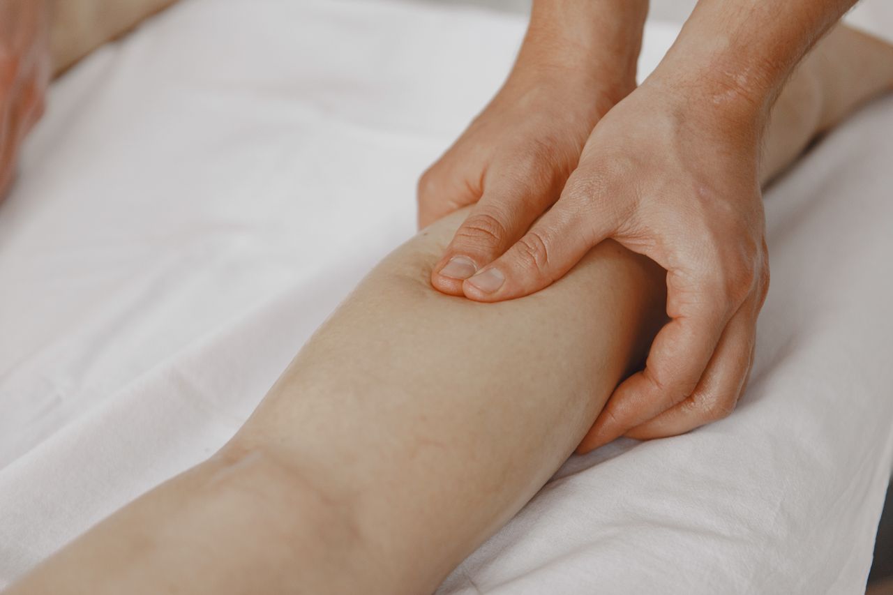 gallery-5 Close-up image of a massage therapist applying pressure on a client's leg for muscle relaxation.